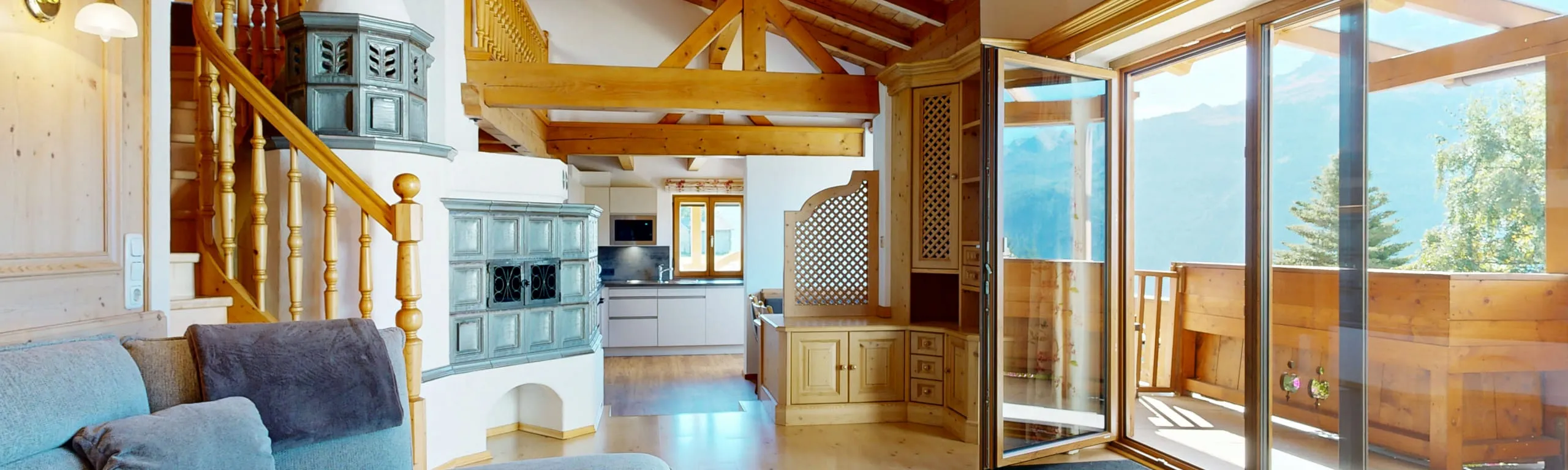 Heller Innenraum eines Chalets mit Holzdetails und Zugang zum Balkon.