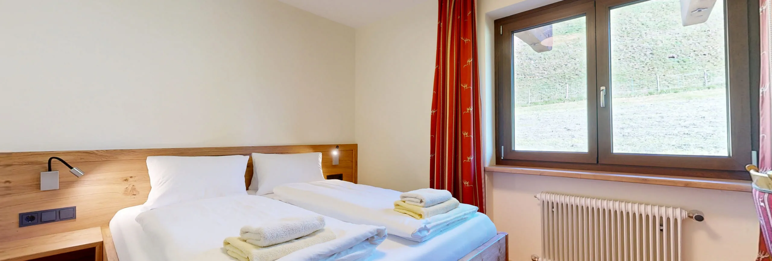 helles Familienzimmer mit zwei Betten und Blick ins Freie